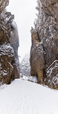 Bir kanyonda karla kaplı bir yol ile manzara