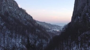Karlı bir nehir vadisi olan kış dağı görüntüleri bir hava aracından çekiliyor.