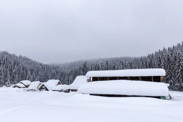 Cabin in the woods, a house covered in snow by the pine forest