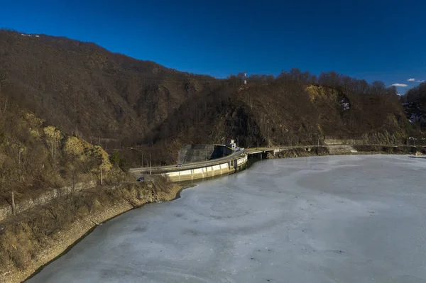 Вид с воздуха на замерзшую реку с плотиной. Красивый зимний пейзаж — стоковое фото