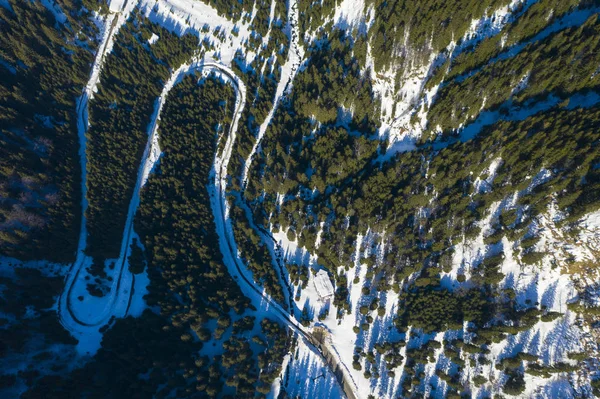 Aerial view of snowy forest with a road. Captured from above wit — Stock Photo, Image