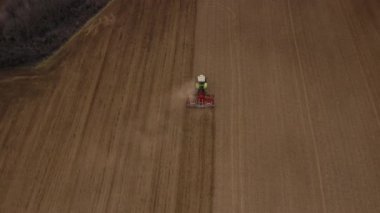 Büyük bir traktör tarlada sürünüyor.