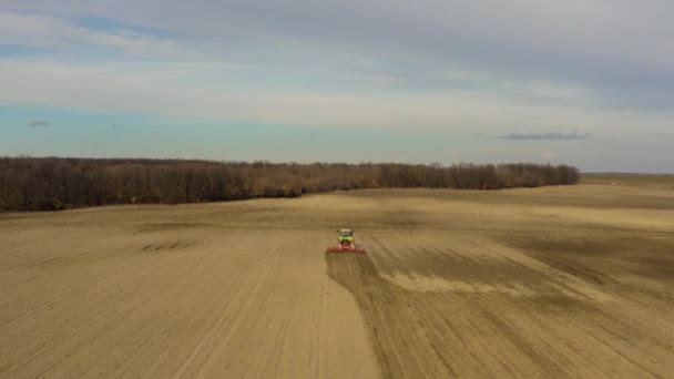 Grand tracteur arrachant un champ labouré 