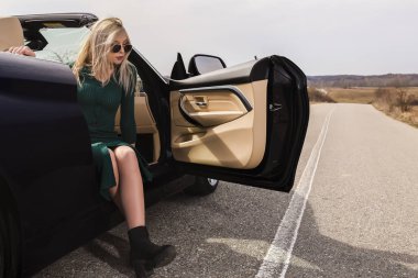 Çekici genç kadın Cabrio araba yaslanarak poz