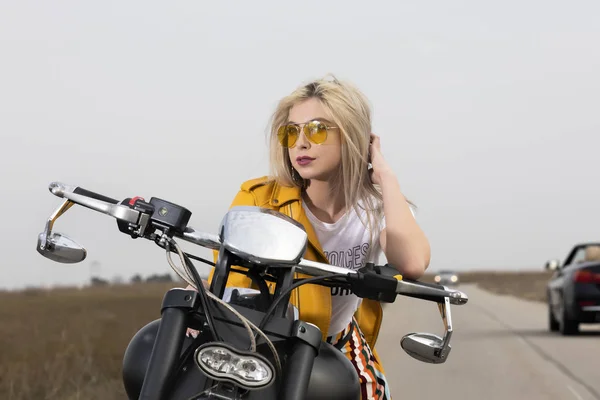 Красива молода жінка сидить на чорно-хромованому мотоциклі — стокове фото