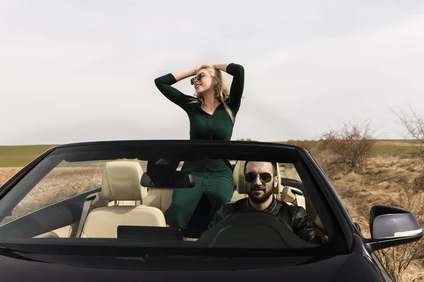 Hermosa pareja joven viajando en un convertible — Foto de Stock