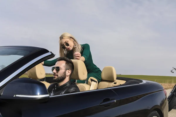 Hermosa pareja joven viajando en un convertible — Foto de Stock