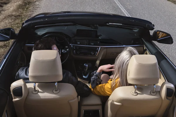 Hermosa pareja joven viajando en un convertible — Foto de Stock