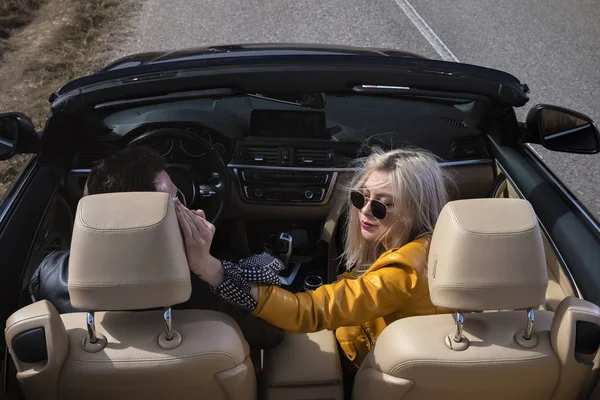 Hermosa pareja joven viajando en un convertible — Foto de Stock