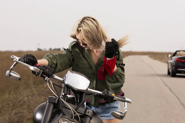 黒とクロームのバイクに座っている美しい若い女性 — ストック写真