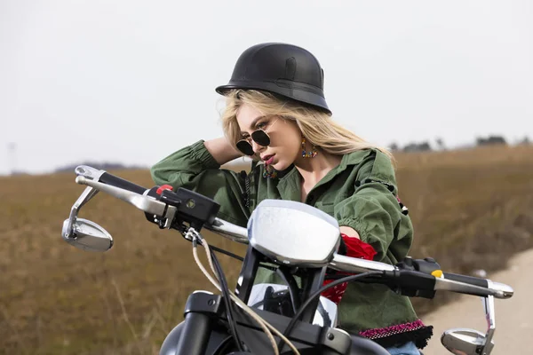 Een mooie jonge vrouw zitten op een motor zwart en chroom — Stockfoto