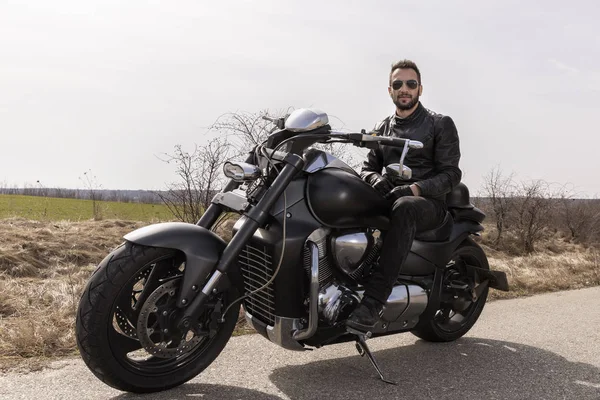 Handsome man on a black classic motorcycle — Stock Photo, Image