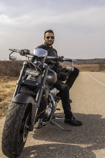 Handsome man on a black classic motorcycle — Stock Photo, Image