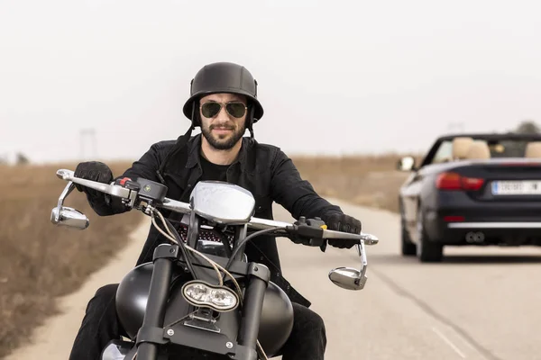 Handsome man on a black classic motorcycle — Stock Photo, Image