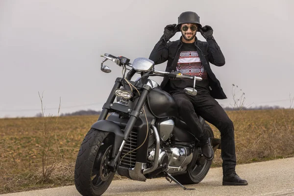 Красивий чоловік на чорному класичному мотоциклі — стокове фото