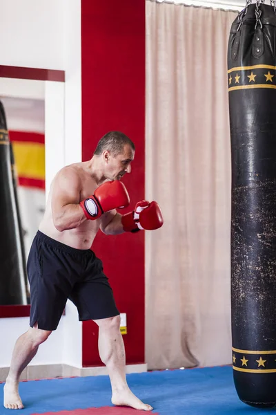 Boxer working with heavy bag — Stock Photo, Image