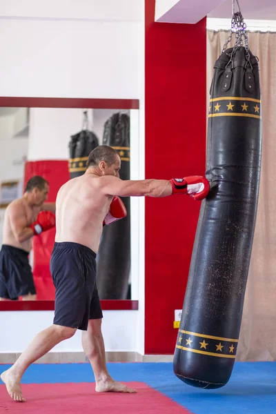 Boxer working with heavy bag — Stock Photo, Image