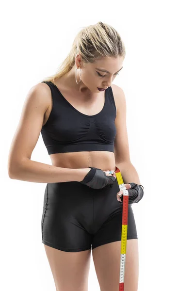 Fit woman measuring her waist - isolated over a white background — Stock Photo, Image