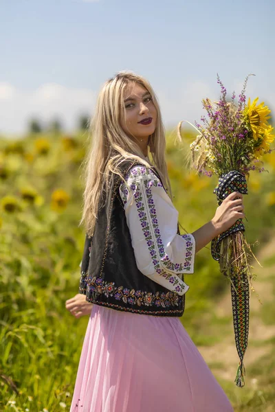 Vacker flicka i traditionell kostym i ett fält — Stockfoto