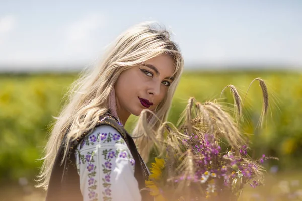 Mooi meisje in traditioneel kostuum in een tarwe veld — Stockfoto