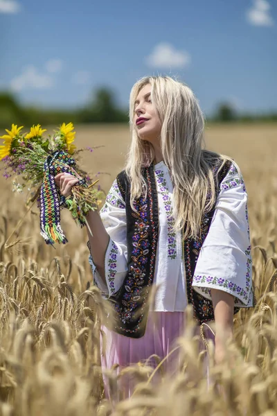 Красива дівчина в традиційному костюмі на пшеничному полі — стокове фото