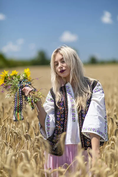 Hermosa chica en traje tradicional en un campo de trigo —  Fotos de Stock