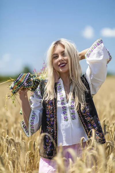 Hermosa chica en traje tradicional en un campo de trigo — Foto de Stock
