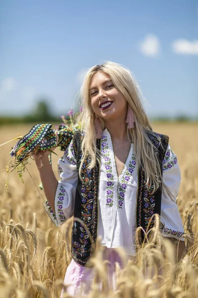 Schönes Mädchen in traditioneller Tracht in einem Weizenfeld — Stockfoto