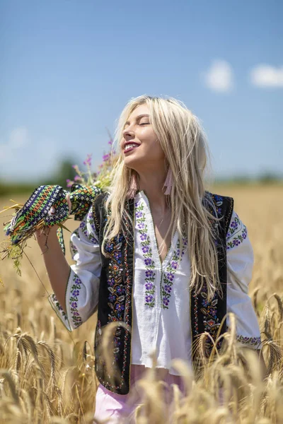 Hermosa chica en traje tradicional en un campo de trigo — Foto de Stock