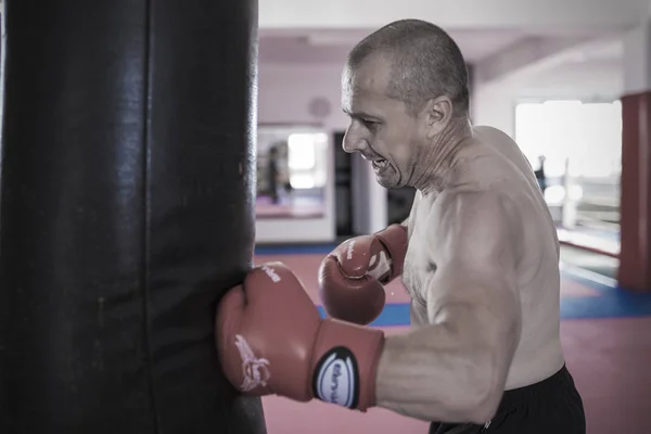 Muay thai lutador batendo o saco pesado no ginásio — Fotografia de Stock