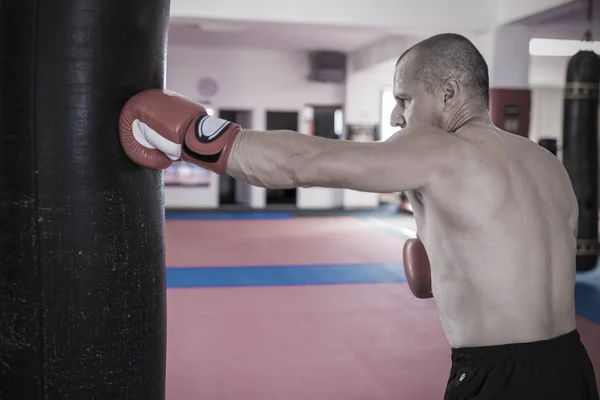 Muay thai combattant frapper le sac lourd dans la salle de gym — Photo