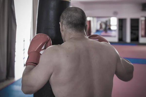 Muay thai lutador batendo o saco pesado no ginásio — Fotografia de Stock