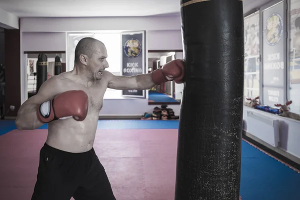 Muay thai vechter raken de zware zak in de sportschool — Stockfoto