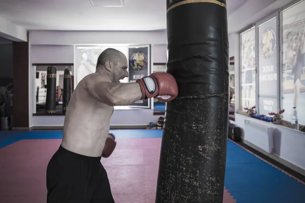 Muay thai lutador batendo o saco pesado no ginásio — Fotografia de Stock