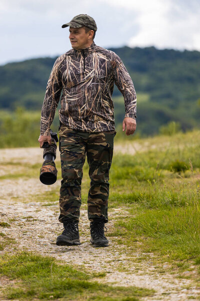 Professional wildlife photographer in camouflage clothing