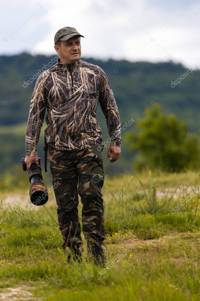 Professional wildlife photographer in camouflage clothing