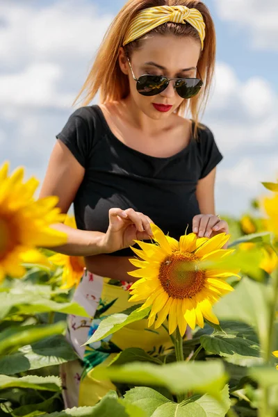 Pretty young woman on a sunflowers field