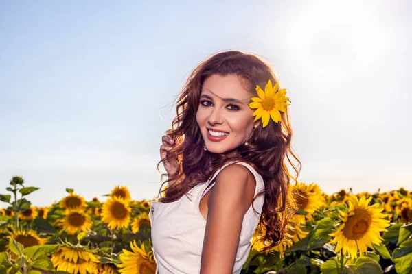 在阳光明媚的夏日 美丽的女人拿着向日葵在农田里摆姿势 — 图库照片