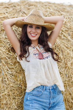 Güzel kovboy kadın samanlıkta poz veriyor, moda konsepti..