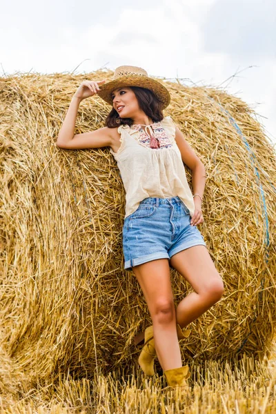 美丽的牛仔女人紧盯着草垛 时尚的概念 — 图库照片