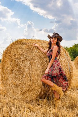 Güzel kovboy kadın samanlıkta poz veriyor, moda konsepti..