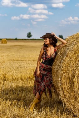Güzel kovboy kadın samanlıkta poz veriyor, moda konsepti..