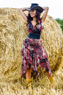 Güzel kovboy kadın samanlıkta poz veriyor, moda konsepti..