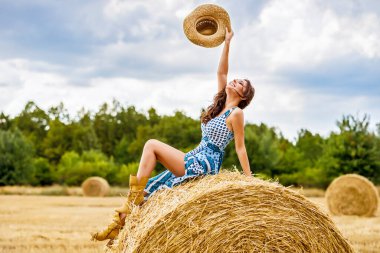 Güzel kovboy kadın samanlıkta poz veriyor, moda konsepti..