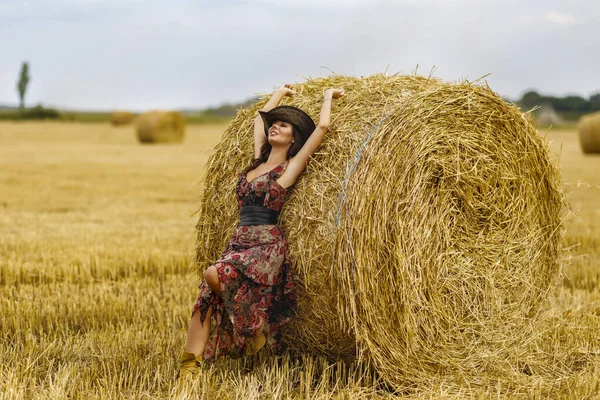 美しいカウボーイの女性が干し草の山の近くにポーズ ファッションコンセプト — ストック写真