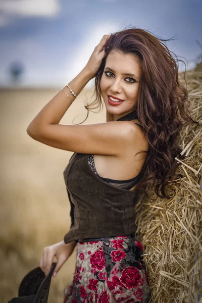 Beautiful cowboy woman Posing near at the haystacks, Fashion concept.