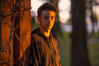 Sonbahar doğal ortamında sonbahar kıyafetleri içinde genç ve yakışıklı bir adam.