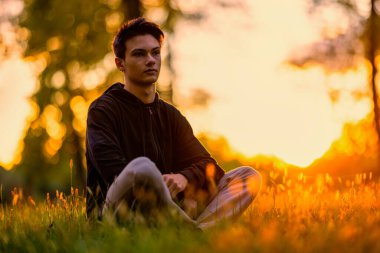 Sonbahar doğal ortamında sonbahar kıyafetleri içinde genç ve yakışıklı bir adam.