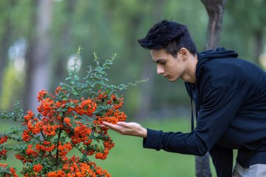 Sonbahar doğal ortamında sonbahar kıyafetleri içinde genç ve yakışıklı bir adam.