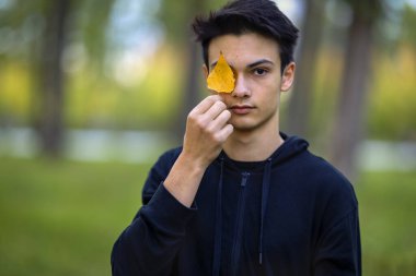 Sonbahar doğal ortamında sonbahar kıyafetleri içinde genç ve yakışıklı bir adam.